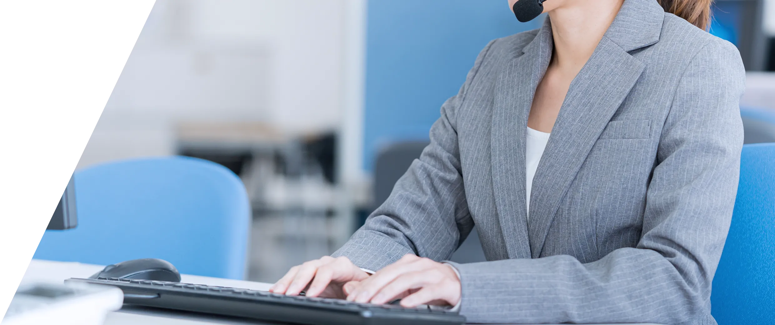 オフィスでマスクを着用してパソコンを操作するビジネスウーマン。