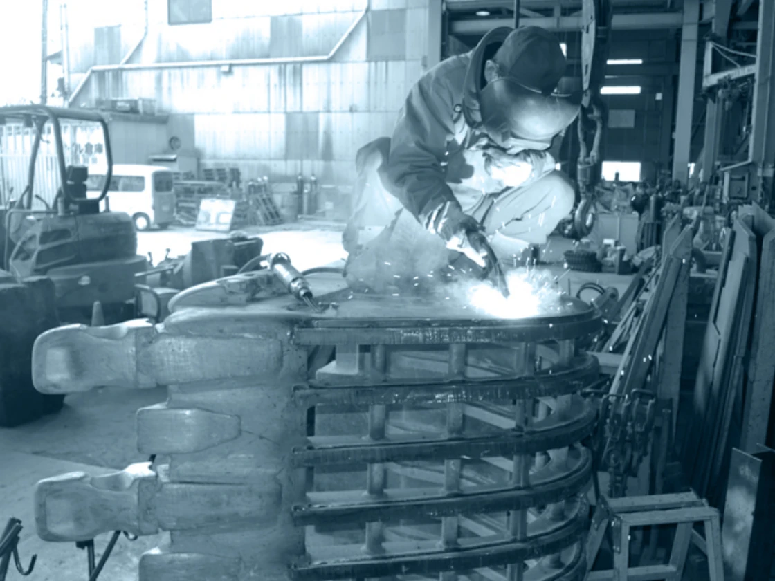 工場内で溶接作業を行う作業員の画像