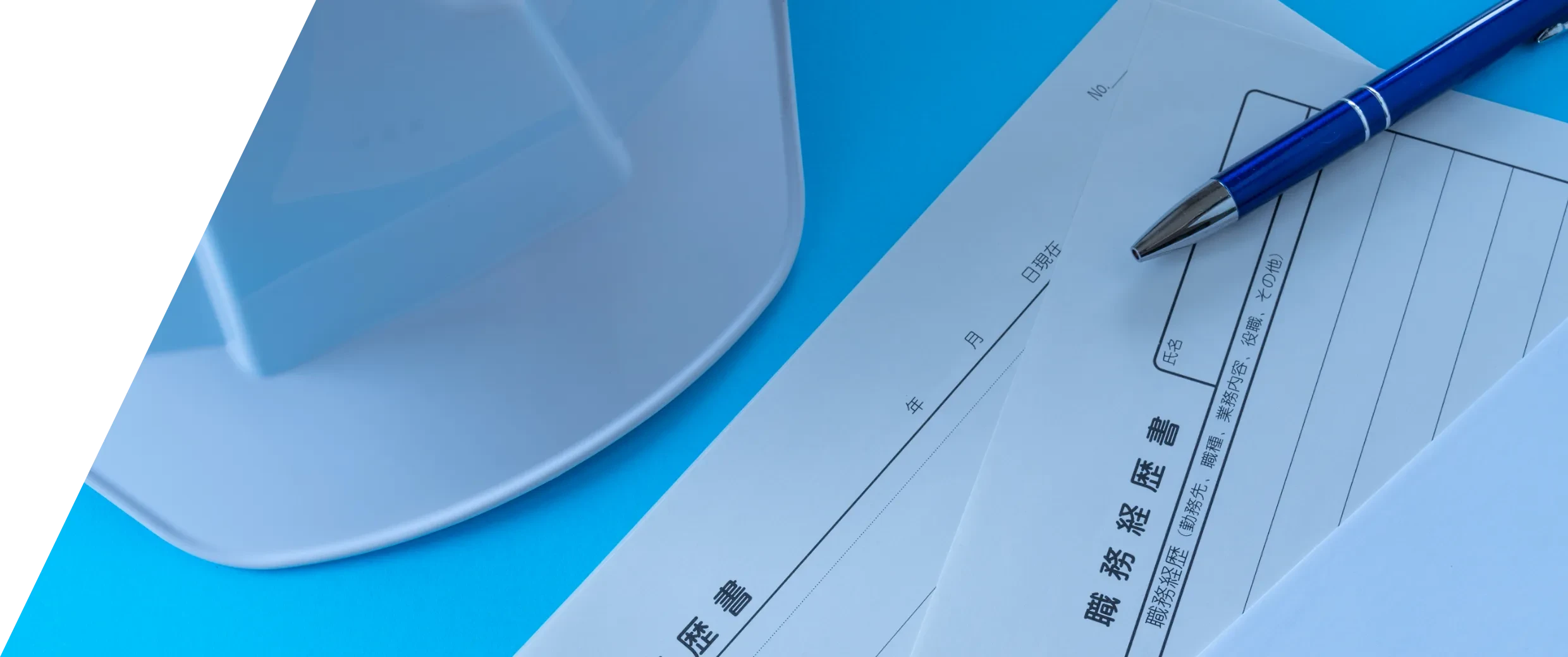 建設ヘルメットと履歴書用紙、ボールペン